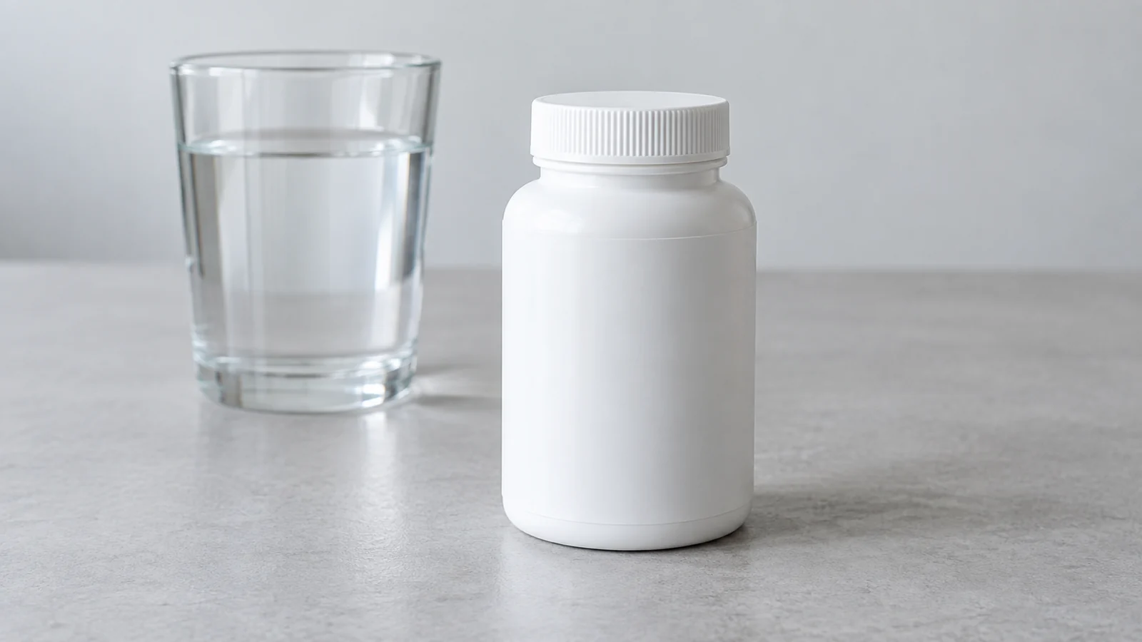 Flacon de complément sans marque et verre d’eau